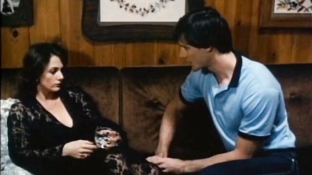 Hottie Wilder in taboo couch talk with hunk, deep V dress