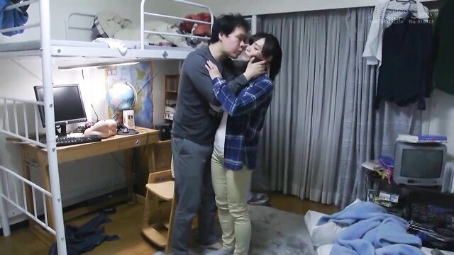 Asian MILF passionately kissing clothed guy in dorm room