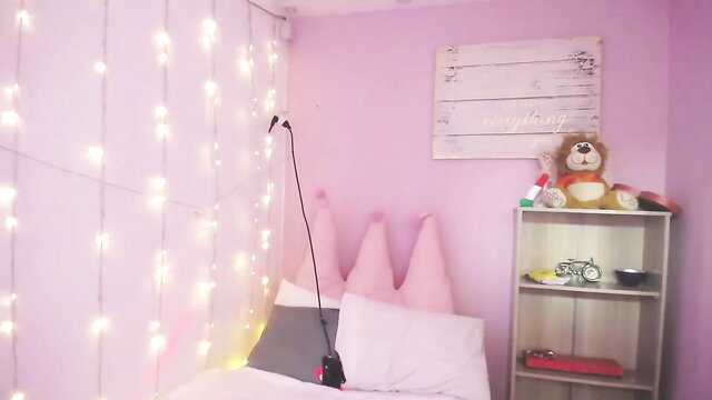 Busty teen in pink bedroom with cone pillows and teddy bear