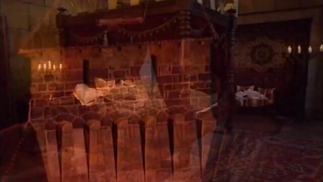 Mystery brunette in red lingerie on ornate bed, candlelit boudoir tease