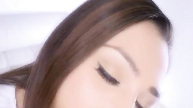 Closeup of seductive Asian woman's half-closed eyes and glossy lips