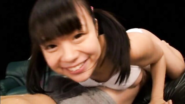 Cute Japanese JAV girl with pigtails smiles in closeup fellatio pose