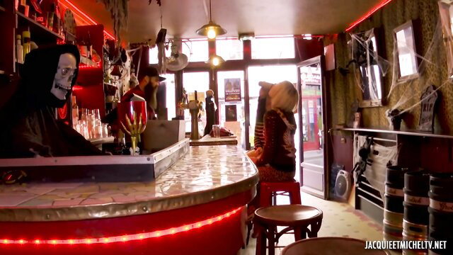 Halloween bar couple in costumes, woman bent over bar counter tease