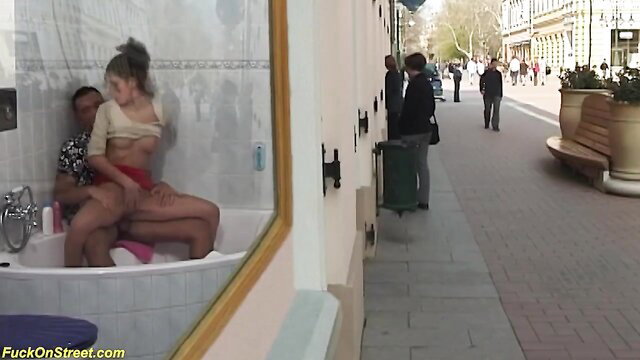 Mixed race girls scissoring pussies in public glass bathtub on street