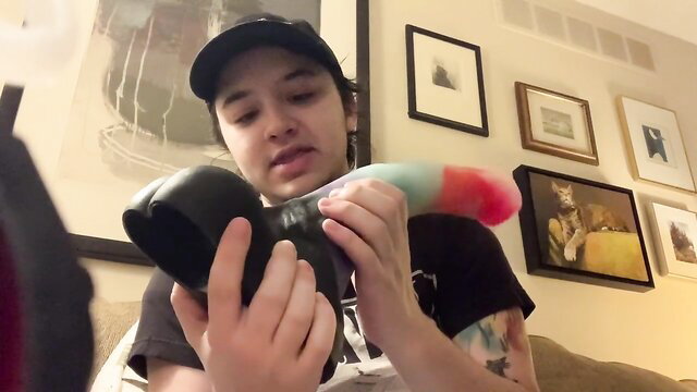 Androgynous person unboxes colorful custom dildo from Exotic Erotics