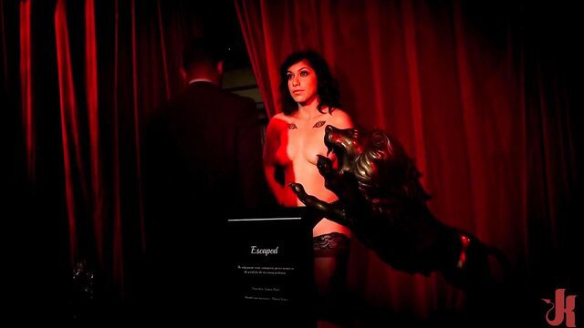 Veronica Avluv nude with wolf statue in red lit erotic scene