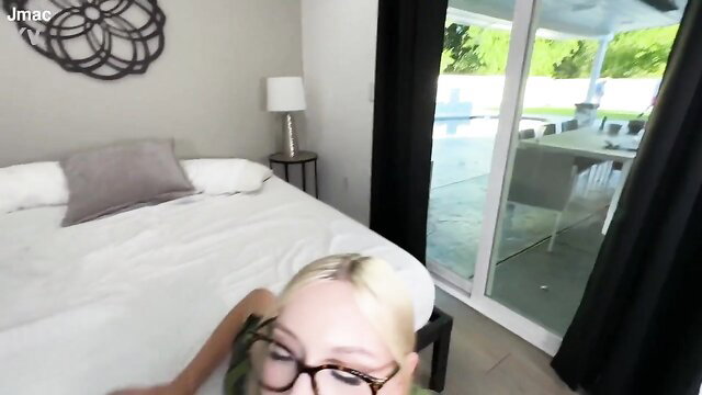 Blonde in glasses on bed ready to be drilled by instructor
