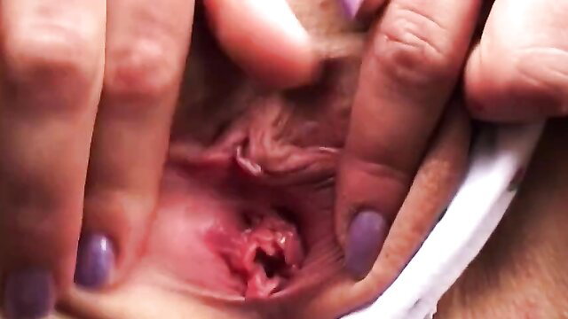 German babe's pink shaved pussy spread wide by fingers closeup