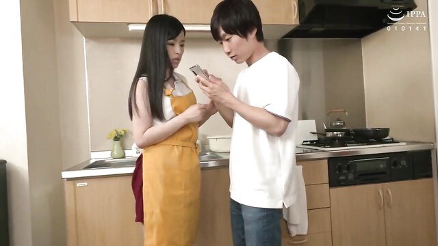 Japanese MILF in apron with son's friend checking phone in kitchen
