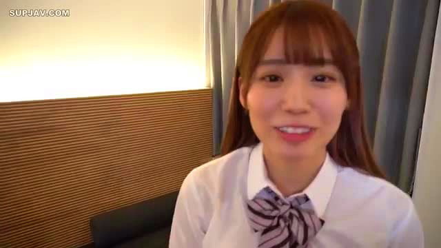 Cute Japanese girl in school uniform with bangs smiles at camera