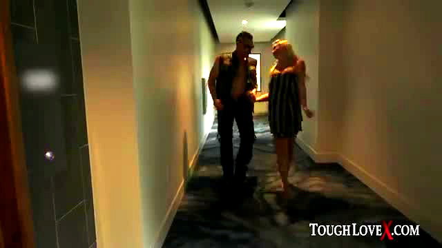 Paisley Porter in short dress walks hotel hallway with tough guy