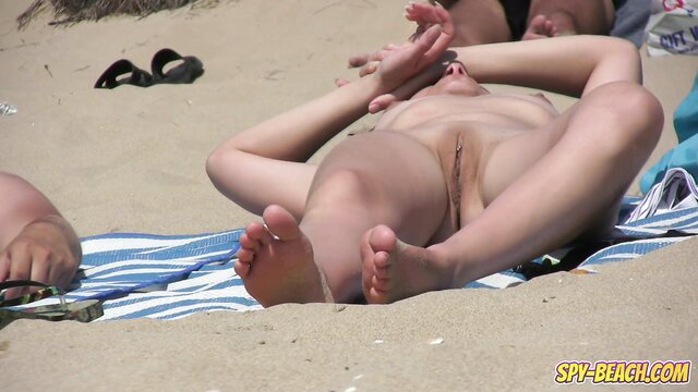Amateur nudist voyeur closeup of pierced pussy on beach