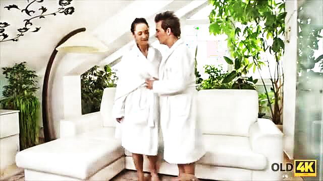 Old lover in robe kisses black-haired Asian MILF in robe close-up
