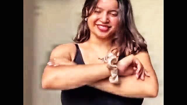 Smiling Filipina MILF with big tits arms crossed in black tank top