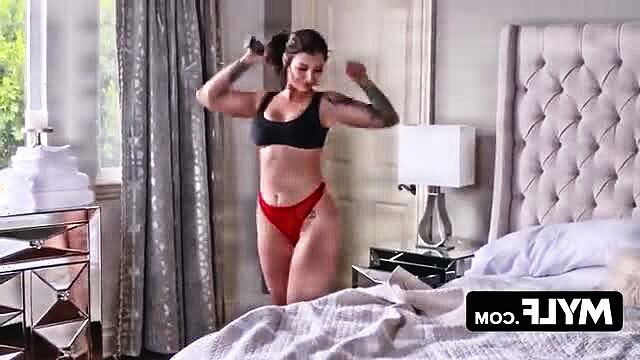 Tattooed Ivy LeBelle in black sports bra and red thong posing seductively