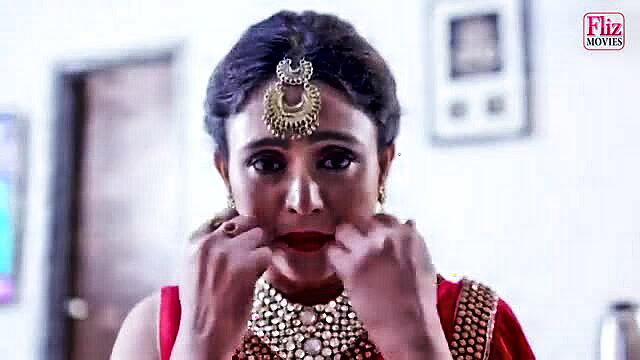 Darkhaired Indian babe in red saree with heavy jewelry teases lips