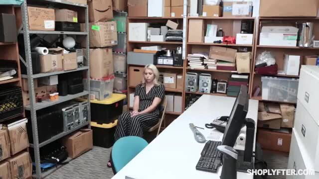 Blondie Chanel in tight black dress sits in office storeroom