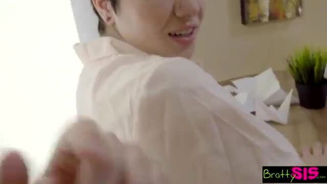 Skinny Asian girl in white blouse smiles as hand reaches from behind