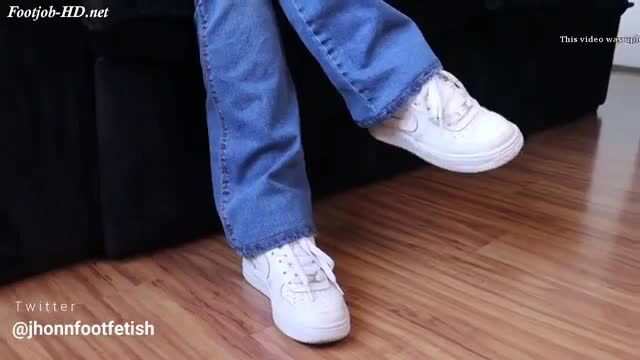 Woman's white Nike Air Force sneakers and bare ankles in blue jeans foot tease