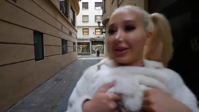 Blonde with mega fake tits in white fur coat on street