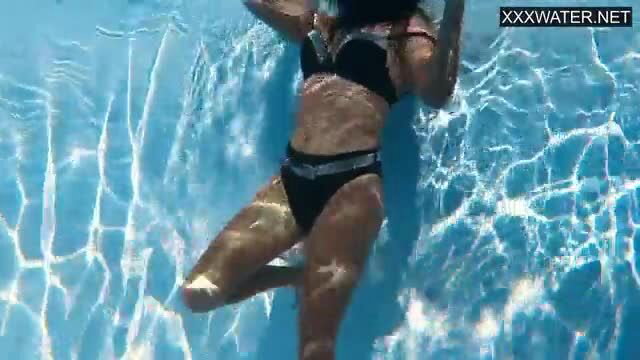 Petite Latina Aghora shows round ass in black bikini pool