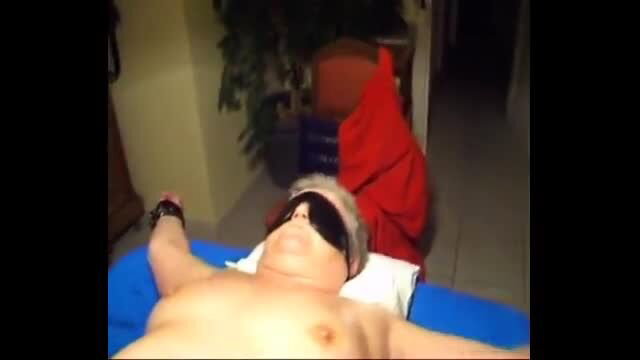 Blindfolded mature man bound naked on bed in kinky setup