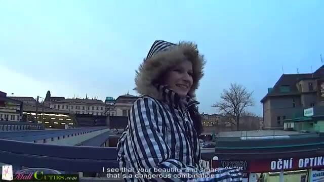 Beautiful smart teen in fur hat and checkered coat on public bridge