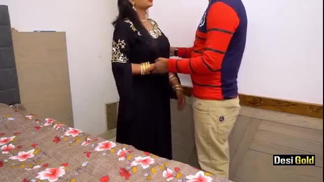 Indian Bhabhi in black embroidered saree embraced by man in red shirt