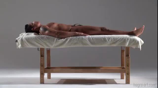 Nude Indian man lying on massage table in erotic body rub