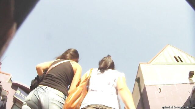 Sexy brunette amateur upskirt view of two girls' asses walking