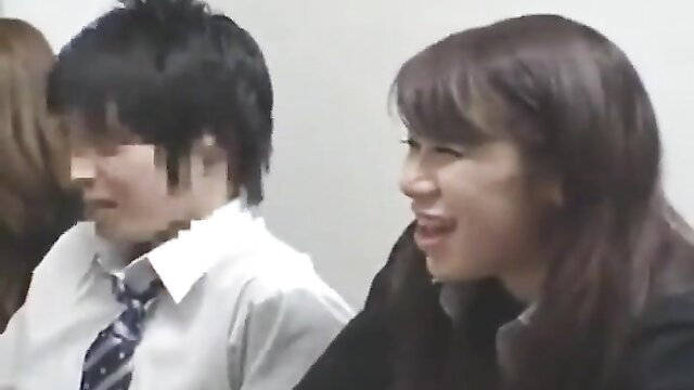 Asian JAV schoolgirl in uniform smiles at suited boy in classroom