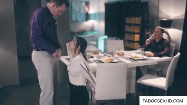 Asian teen kneels for blowjob at dinner table with men watching