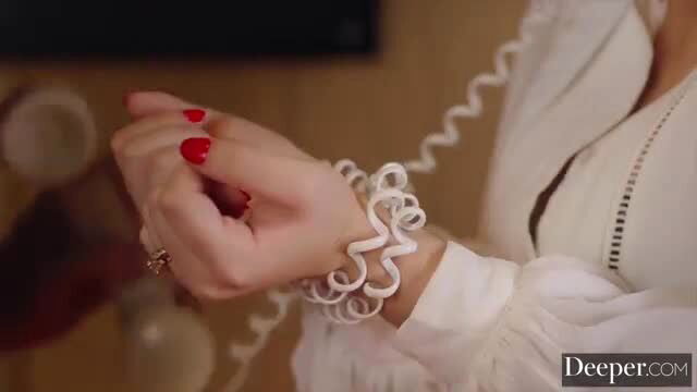 Ellie Nova in white blouse with red nails holding phone cord bondage