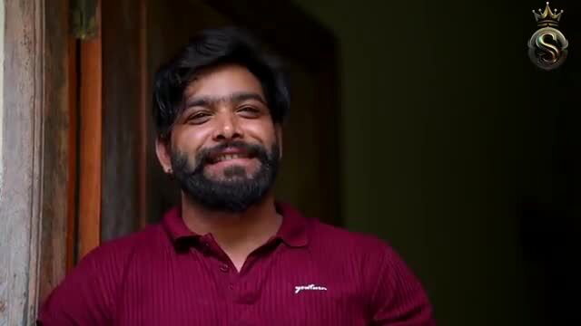 Smiling handsome Indian man in maroon polo shirt closeup
