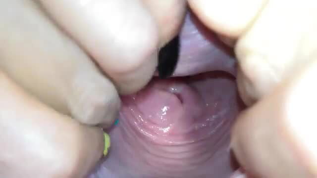 Extreme close-up of pink cervix and vagina, fingers spreading labia