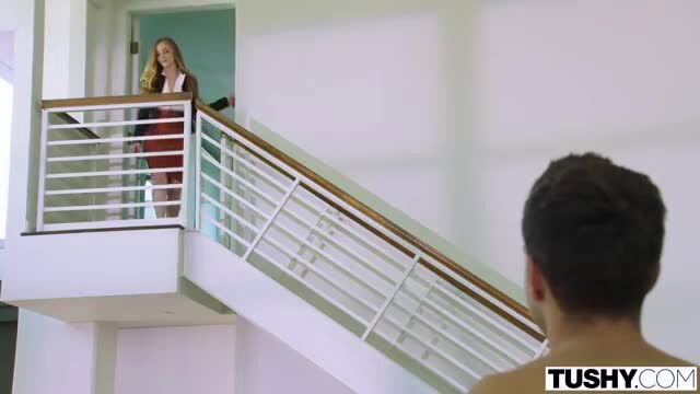 Addison Lee in red dress on stairs in Tushy scene