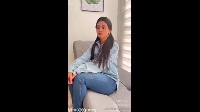 Anna Arango in tight jeans and shirt, seductive seated pose