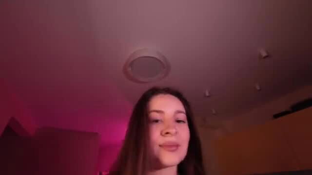 Miss Freyaxxx brunette beauty smiling seductively in pink lit room