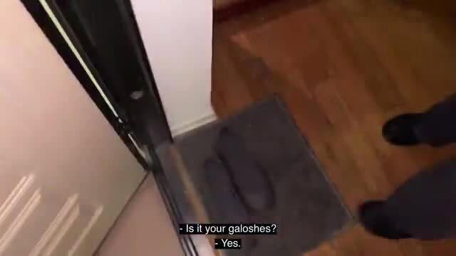 Man at door with galoshes on mat in casual home setting