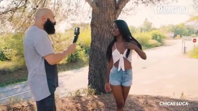 Boni Brown in tiny white bow top and denim shorts by tree