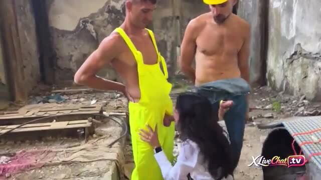 Brunette kneels for construction workers' gangbang in ruins