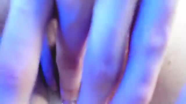 Closeup of woman's juicy blue-lit pussy rubbing clit with toy