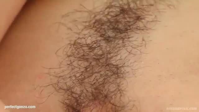 Closeup of woman's hairy pink pussy lips spread in solo tease