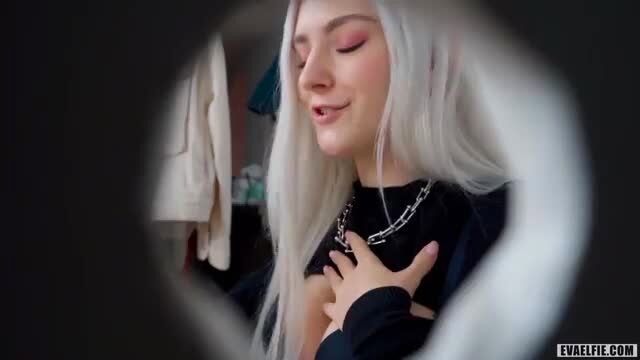 Eva Elfie closeup smile at glory hole, white hair, black top, sexy tease