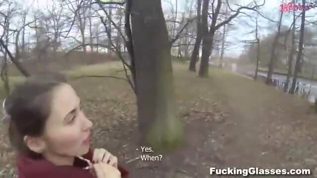 Brunette teen in red top kneels by tree outdoors, asking 'Yes? When?'