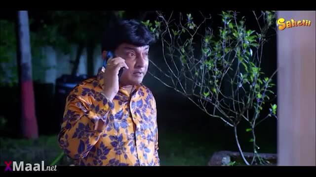 Indian man in orange shirt on phone in seductive housewife video thumbnail