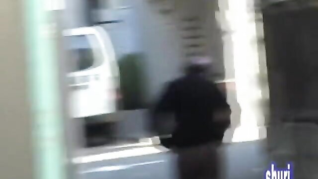 Blurry Asian girl sharking prank in brown sweatpants on street