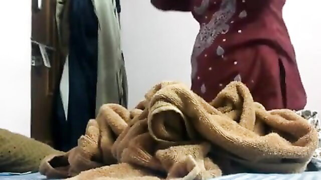 Chubby Indian woman in red salwar kameez with towels, dressing