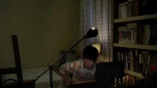 Asian twink in sheer shirt bends over desk in dimly lit JAV bedroom