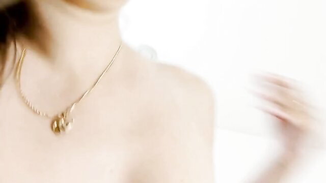 Closeup of sexy Asian stepmom's neckline and gold necklace in taboo video